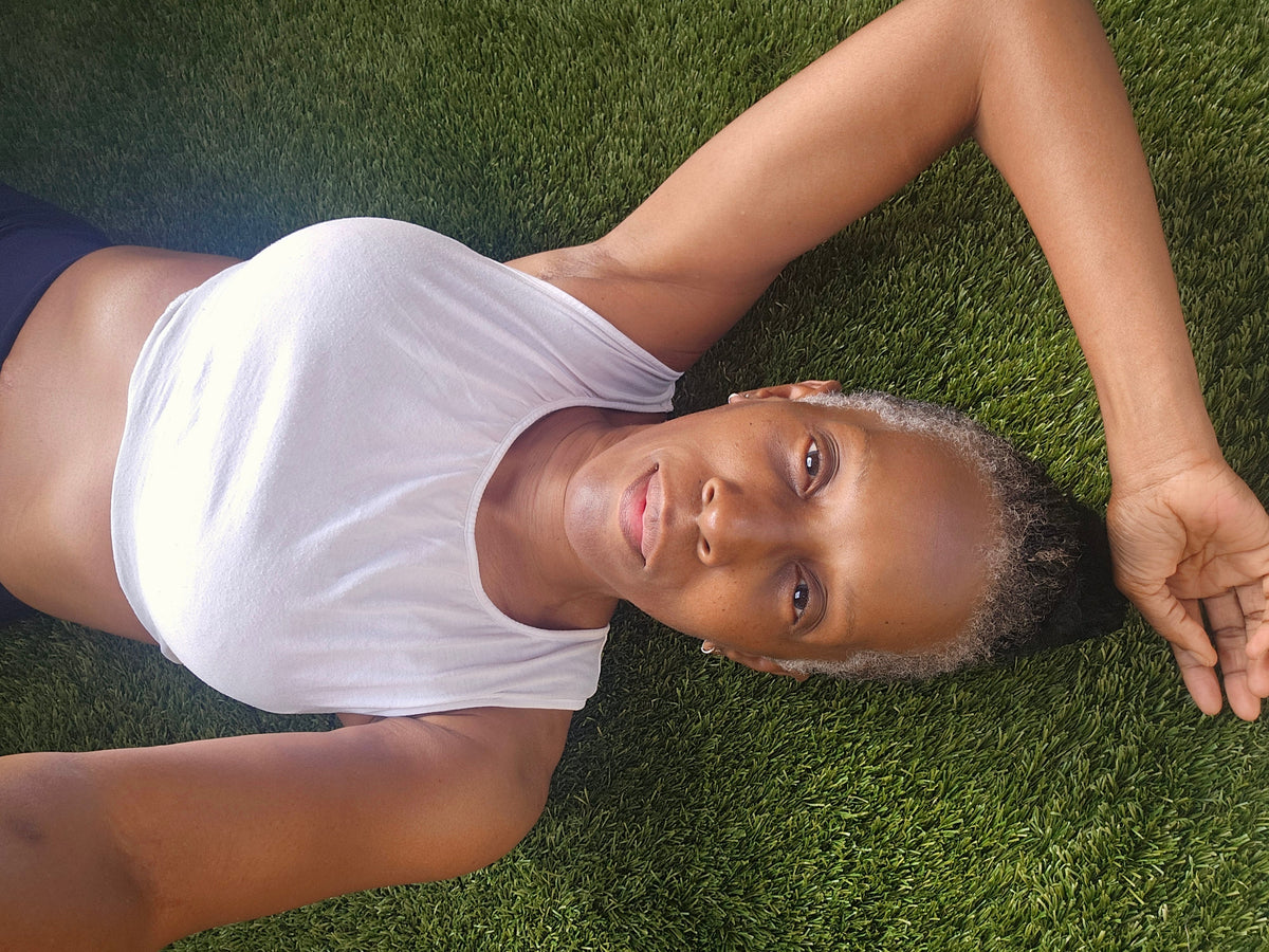 Sonja resting on the grass during a quiet wellness moment.